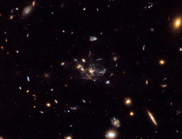 Galaxies in space, with a large wispy galaxy at the centre of the picture.