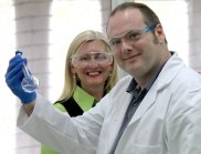 Larissa Bright and Dr Mark York in the lab with a flask of UV filters