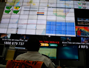 Man sitting in front of a bank of television screens at the NSW RFS control centre.