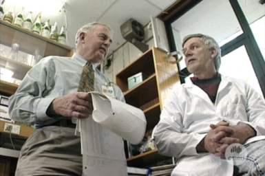 Dr Bob Winks in discussion with fellow researcher in lab.