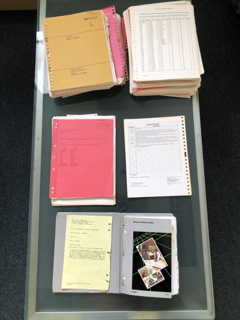 Photograph of CDC manuals, showing covers, and revision in