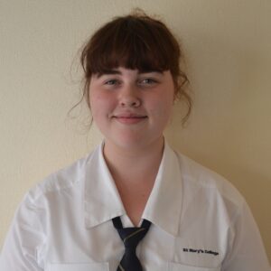 Head and shoulders photo of Greta Stephensen standing in front of a white wall.